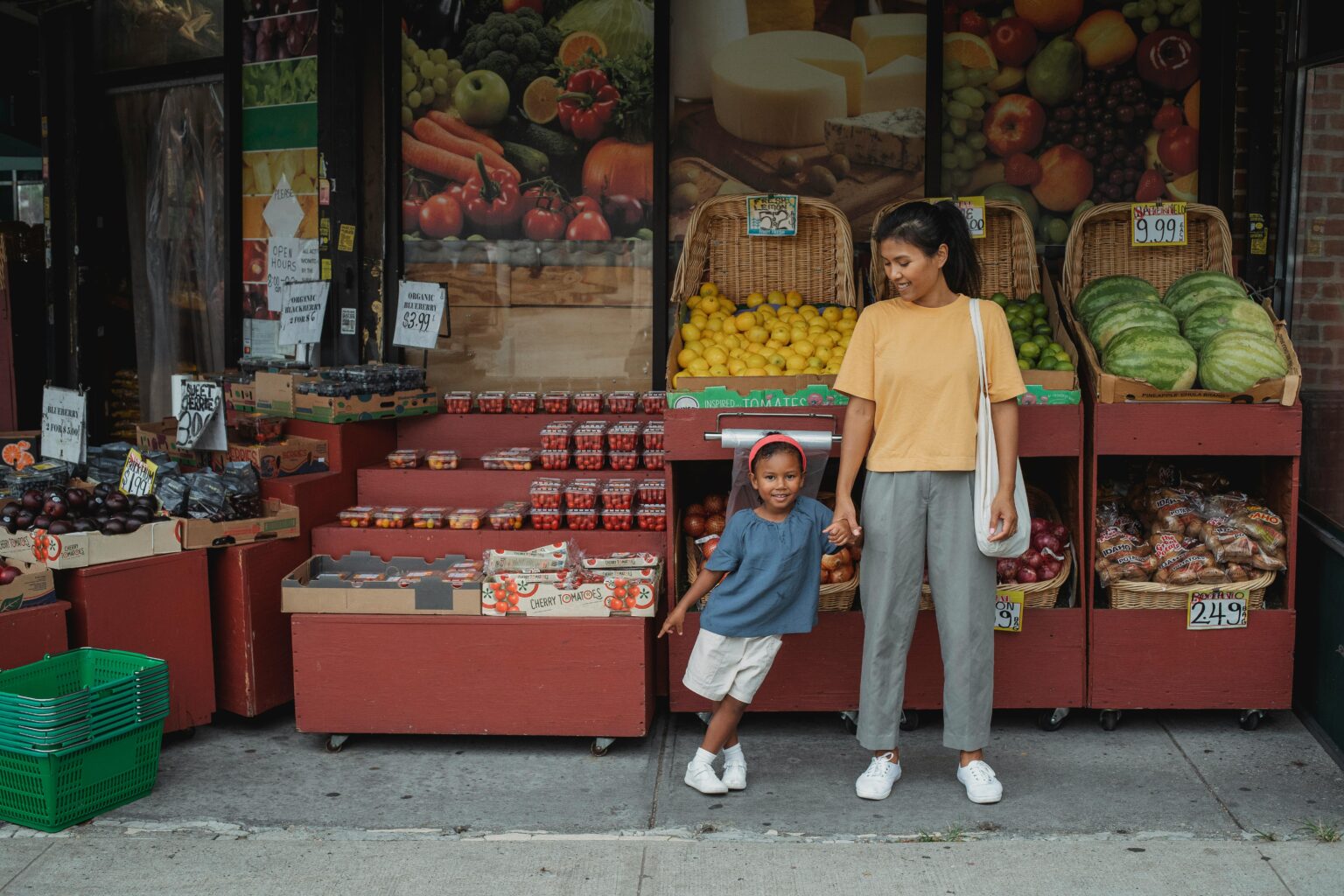 A mother and daughter standing at a vegetable vendor in a nurturing and joyful environment leaving an impact of Positive Parenting.