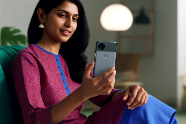 An Indian woman seated, holding a Google Pixel 8a in a brightly lit room